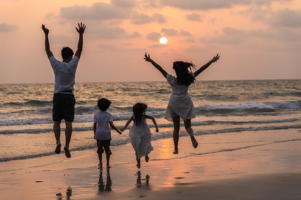 familia feliz joven asiatica disfruta vacaciones playa noche papa mama nino relajan corriendo juntos cerca mar mientras puesta sol silueta concepto estilo vida viajes vacaciones vacaciones verano